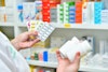 a hand holding pills and bottles